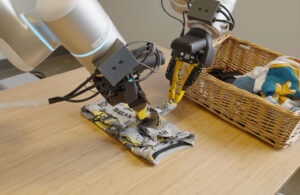 Two robot arms folding a tshirt.