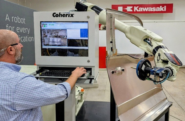 Steven Pagalos, Coherix technical account manager, configures Coherix’s 3D adhesive inspection technology on a door skin during setup for the Kawasaki Robotics exhibit at AUTOMATE 2026.