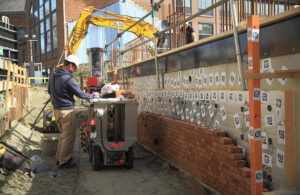 Monumental designs, machines, and maintains robots that lay bricks at construction sites.