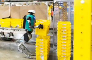 A Digit robot from Agility stacking a yellow crate.