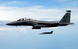 lockheed martin jet over the ocean deploying a missile.
