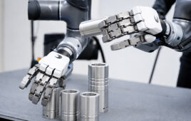 two humanoid robotics hands picking cylindrical items from tables.