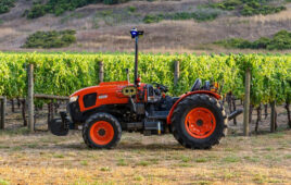 Kubota tractor equipped with agtonomy controls in front of a vineyard.