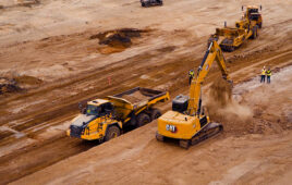 drone image of a bedrock robotics equipped excavator moving dirt.