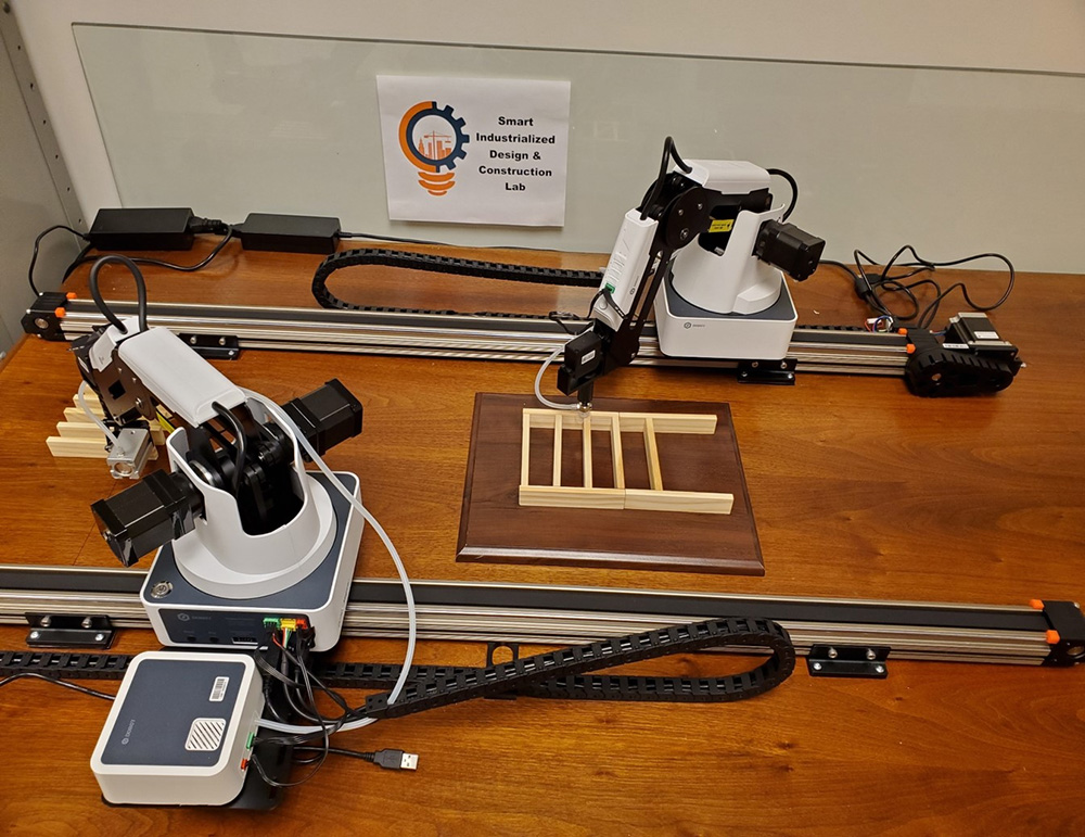image of two table top robots designed to assemble models of building walls.