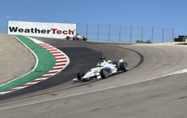 two race cars come through the famous corkscrew turn at Laguna Seca raceway.