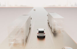 An image of a car driving on a simulated road next to simulated trucks.